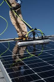 Close-up of a squeegee clearing water from a solar panel