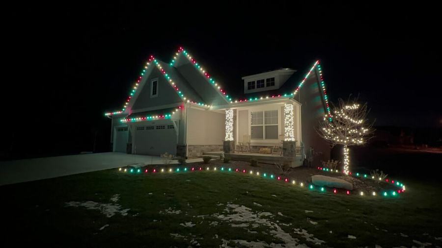 Red and green roofline lighting with a lit yard border