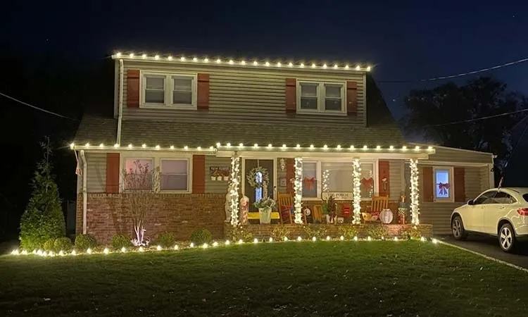 Warm white roofline and yard border lighting on a ranch home